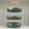 1781617068_WhatsApp_Image_2026-06-12_at_14.26.57-1.jpg Three-tier ceramic serving stand with a gold metal frame