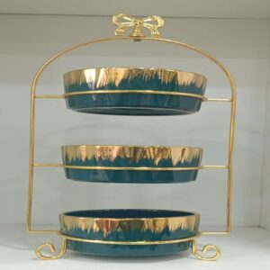 1781617068_WhatsApp_Image_2026-06-12_at_14.26.57-1.jpg Three-tier ceramic serving stand with a gold metal frame