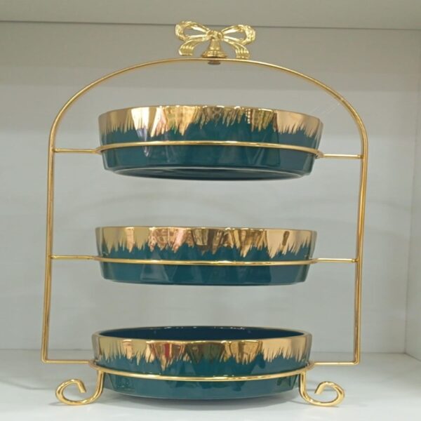 1781617068_WhatsApp_Image_2026-06-12_at_14.26.57-1.jpg Three-tier ceramic serving stand with a gold metal frame