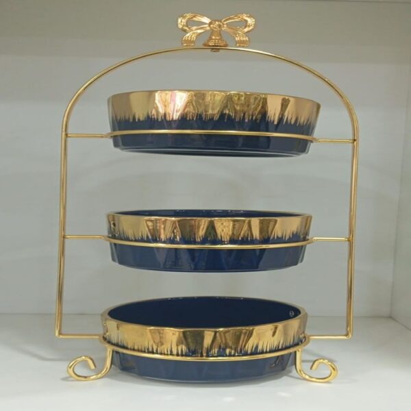1781617069_WhatsApp_Image_2026-06-12_at_14.33.11-1.jpg Three-tier ceramic serving stand with a gold metal frame